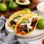 Blackened Cod Tacos on a plate with sauce and cilantro