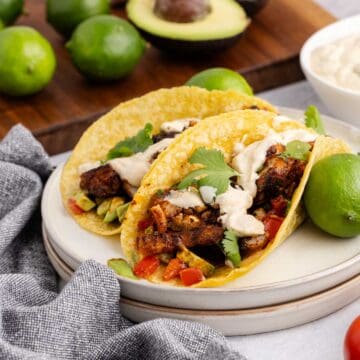 Blackened Cod Tacos on a plate with sauce and cilantro
