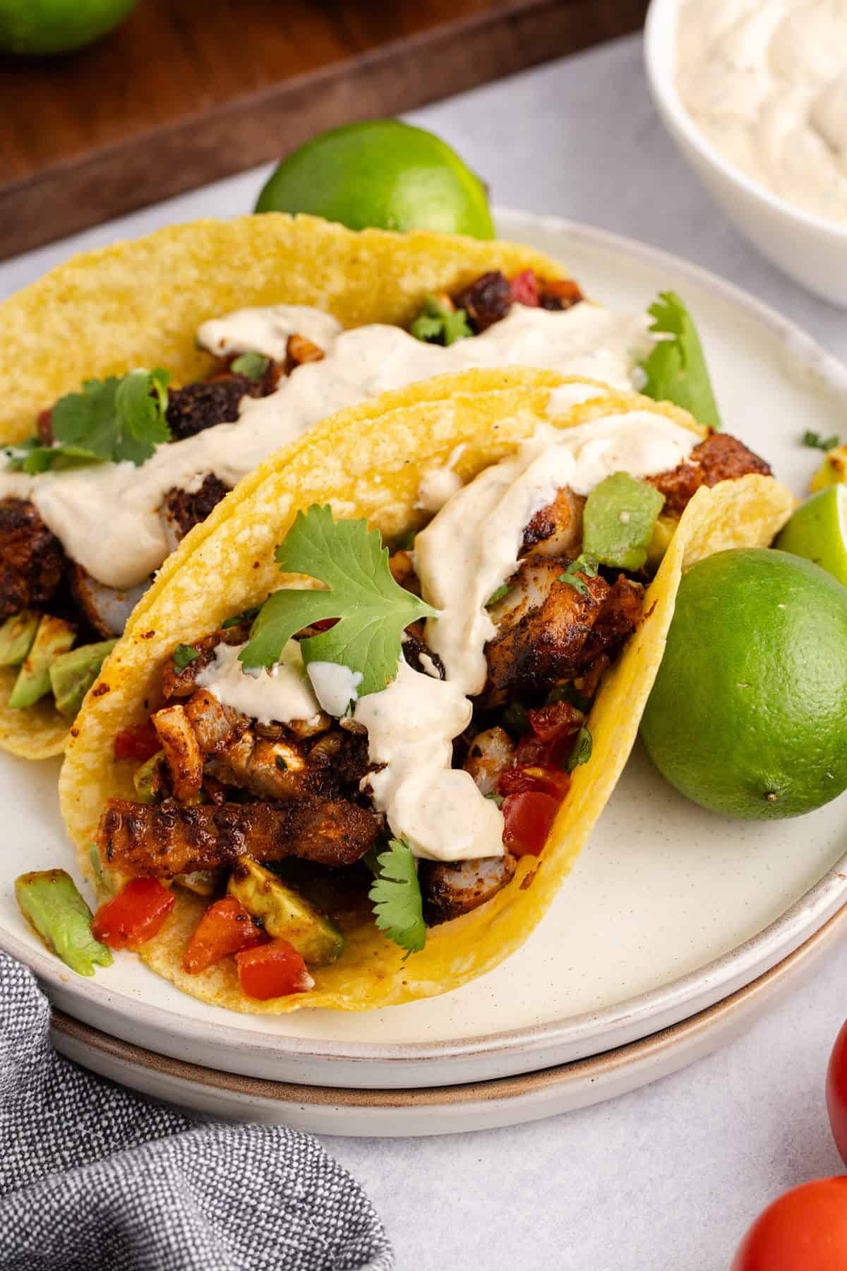 Blackened Cod Tacos on a plate with sauce and cilantro