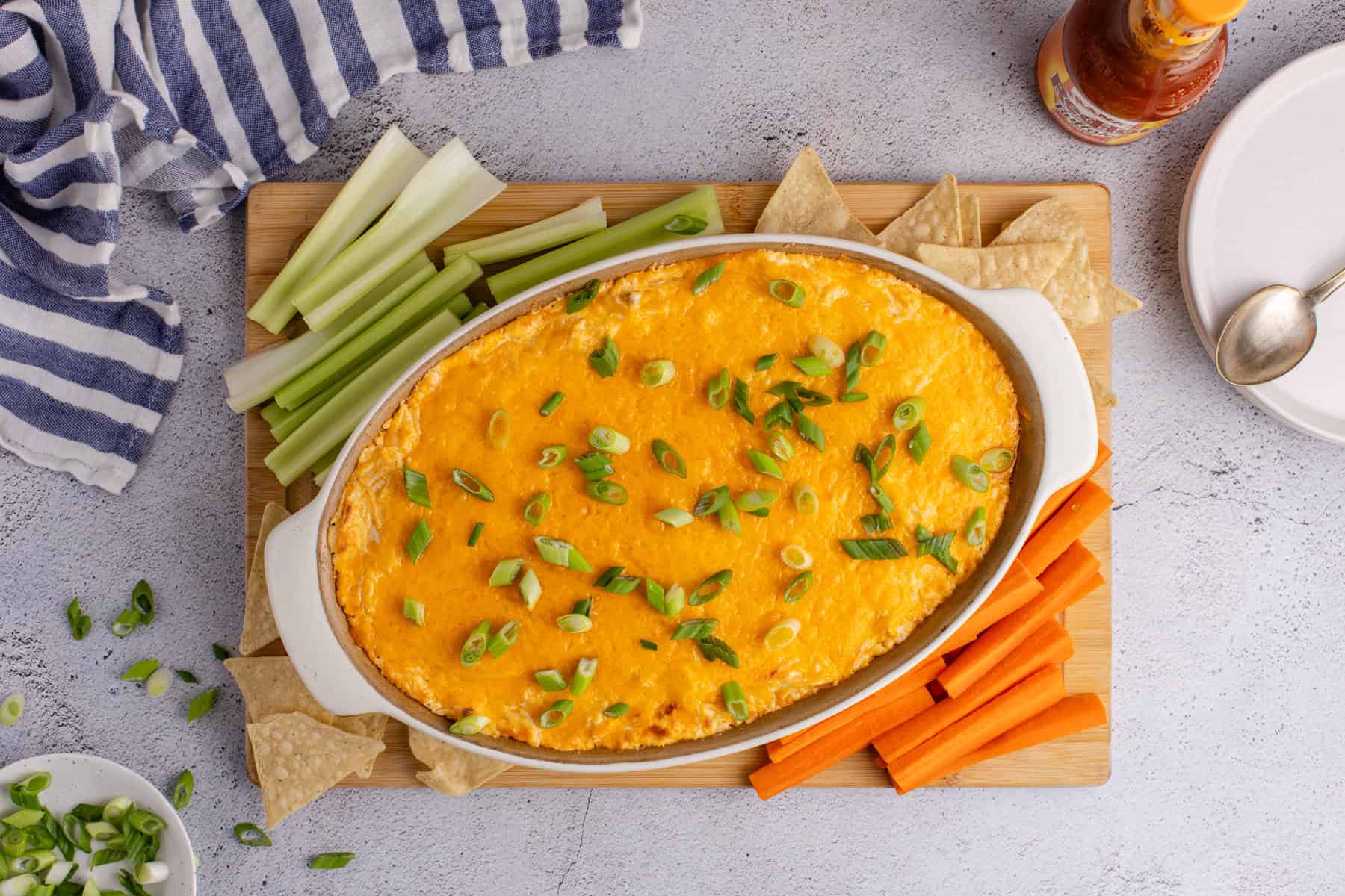 Buffalo Chicken Wing Dip with Rotisserie Chicken baked in a dish from above with veggies and chips