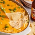 Buffalo Chicken Wing Dip with Rotisserie Chicken baked in a dish with corn chips