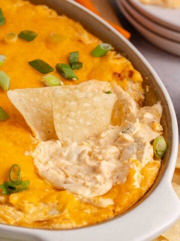 Buffalo Chicken Wing Dip with Rotisserie Chicken baked in a dish with corn chips
