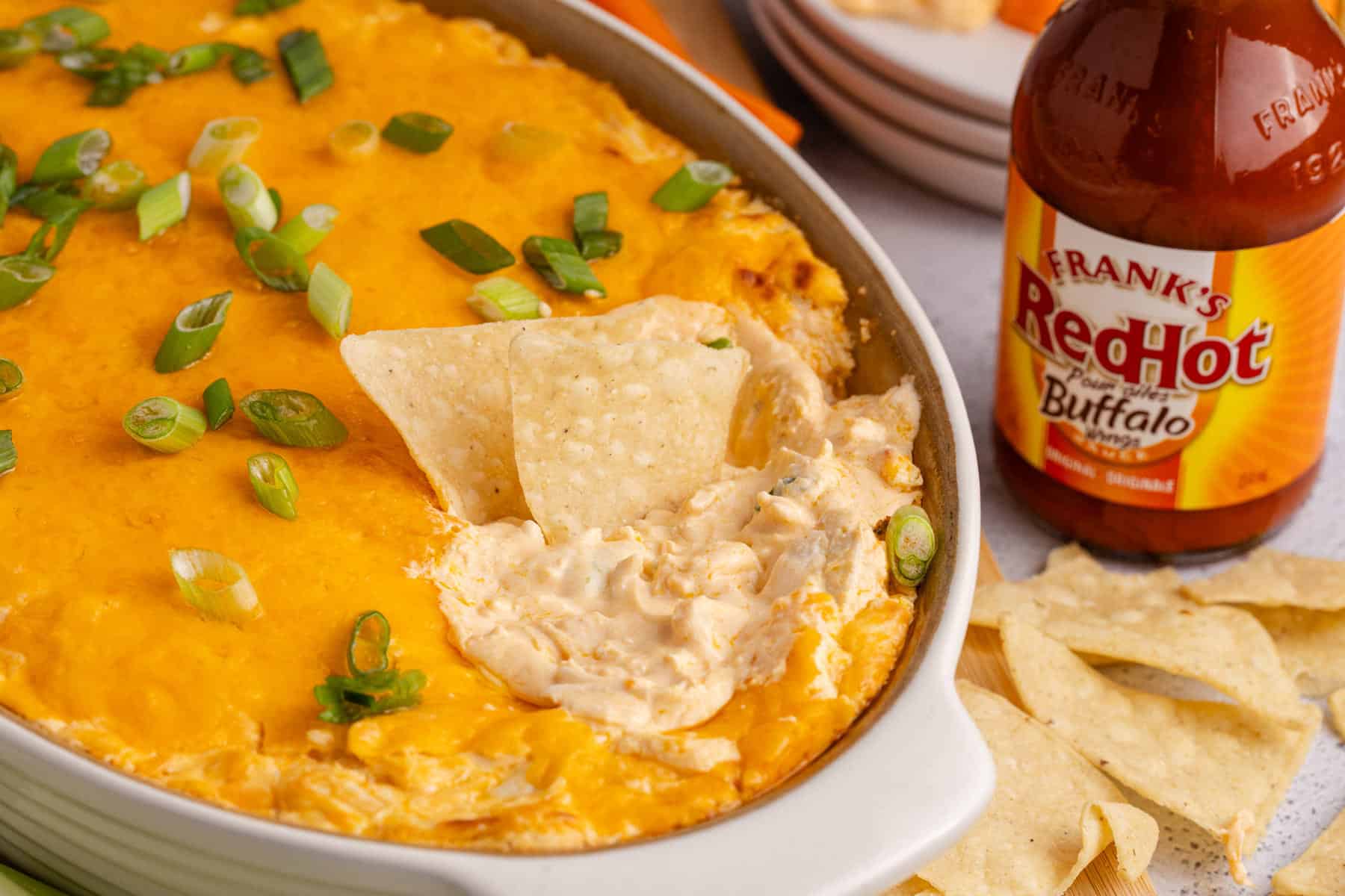 Buffalo Chicken Wing Dip with Rotisserie Chicken baked in a dish with a corn chips