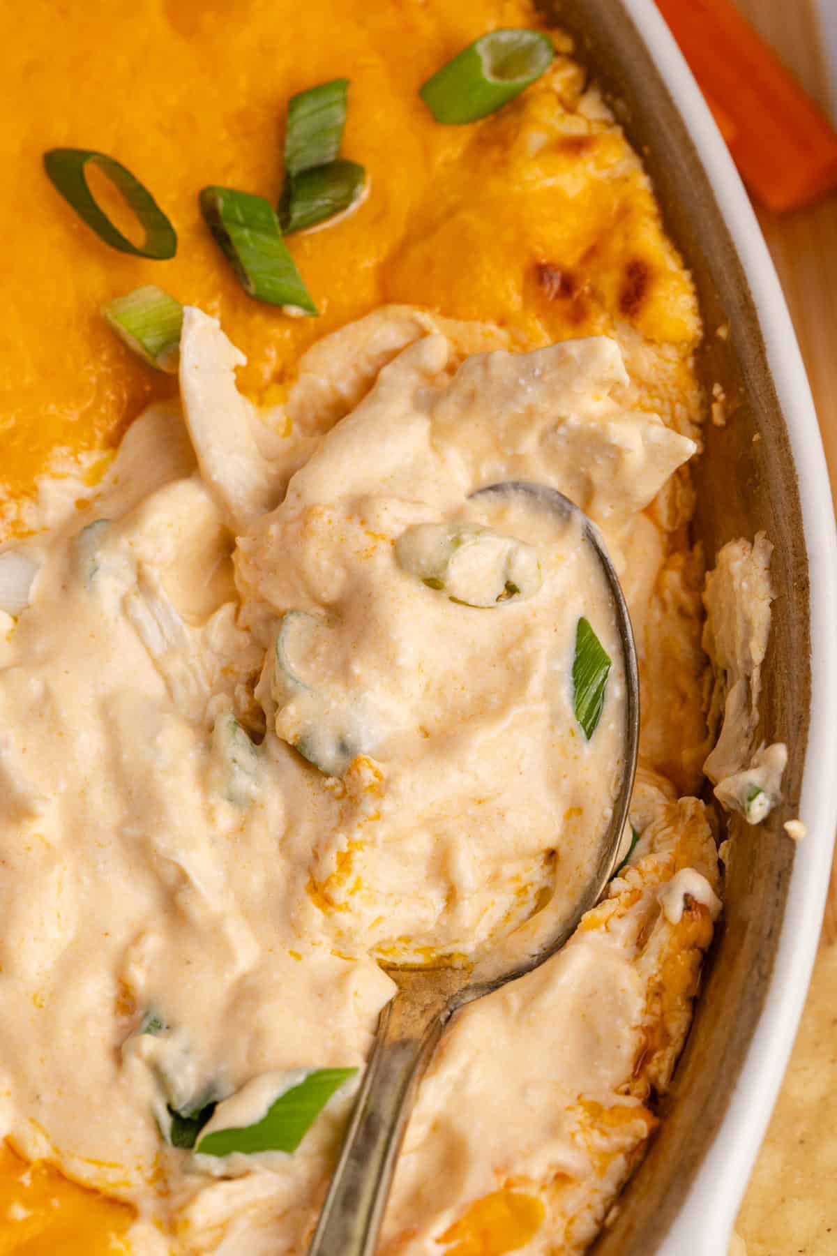 Buffalo Chicken Wing Dip with Rotisserie Chicken baked in a dish from above with a spoonful