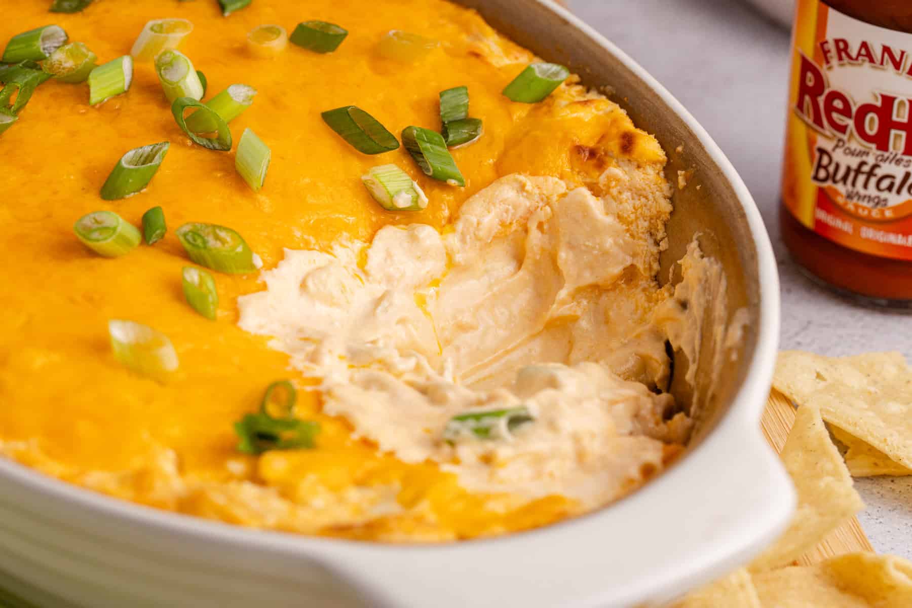 Buffalo Chicken Wing Dip with Rotisserie Chicken baked in a dish with a scoop out