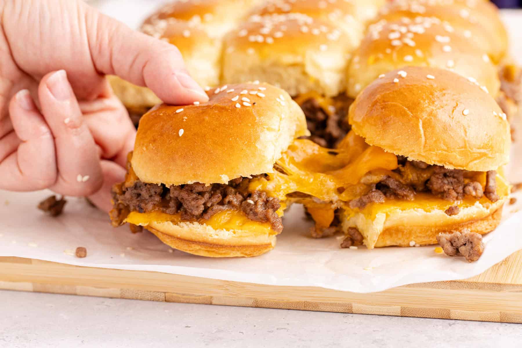 Cheeseburger Sliders with cheese pulling from one to another