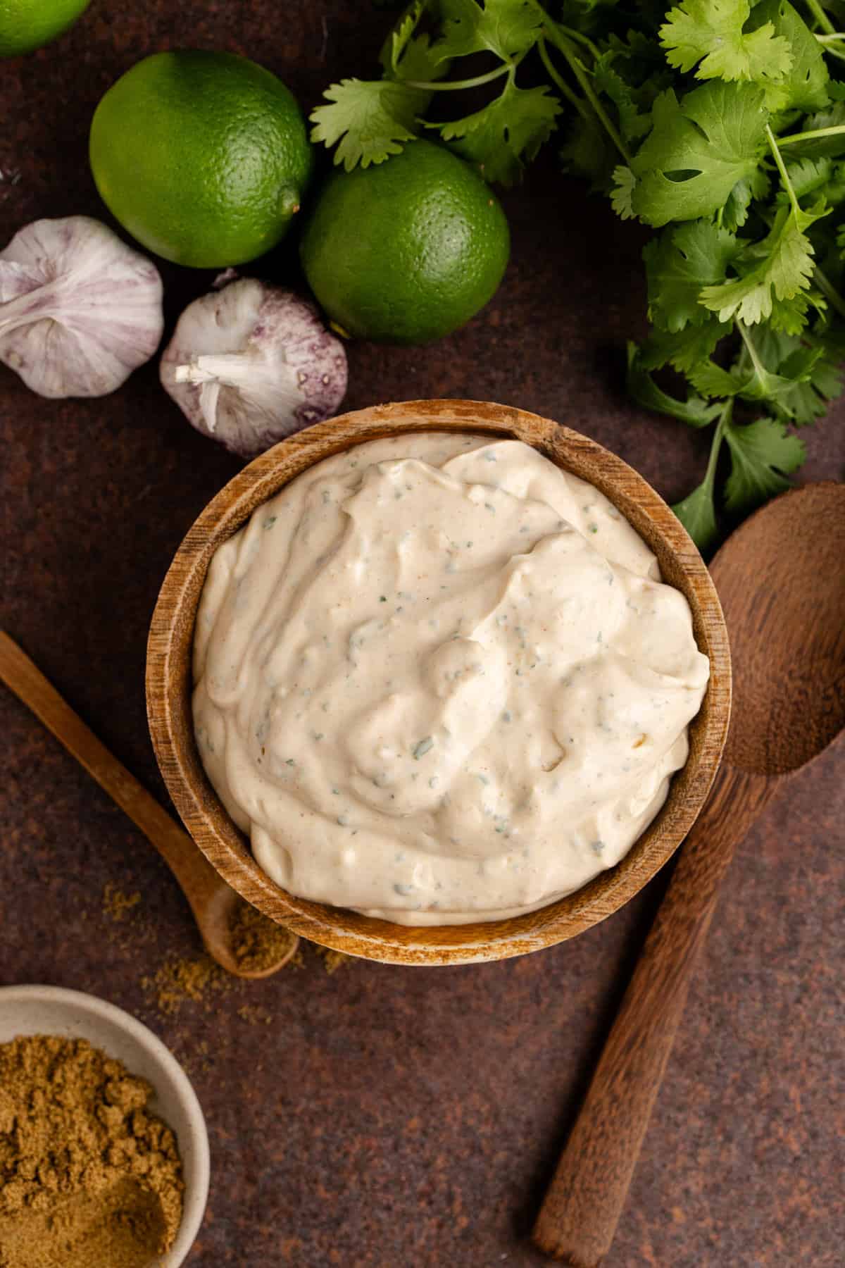 Fish Sauce in a bowl with fresh cilantro, limes and garlic all around