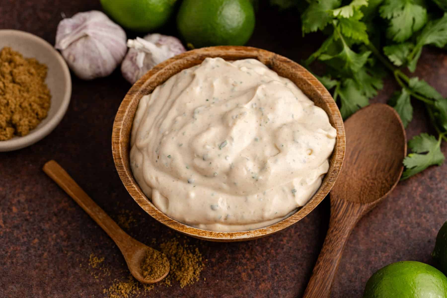 Fish Sauce in a bowl with fresh cilantro, limes and garlic all around