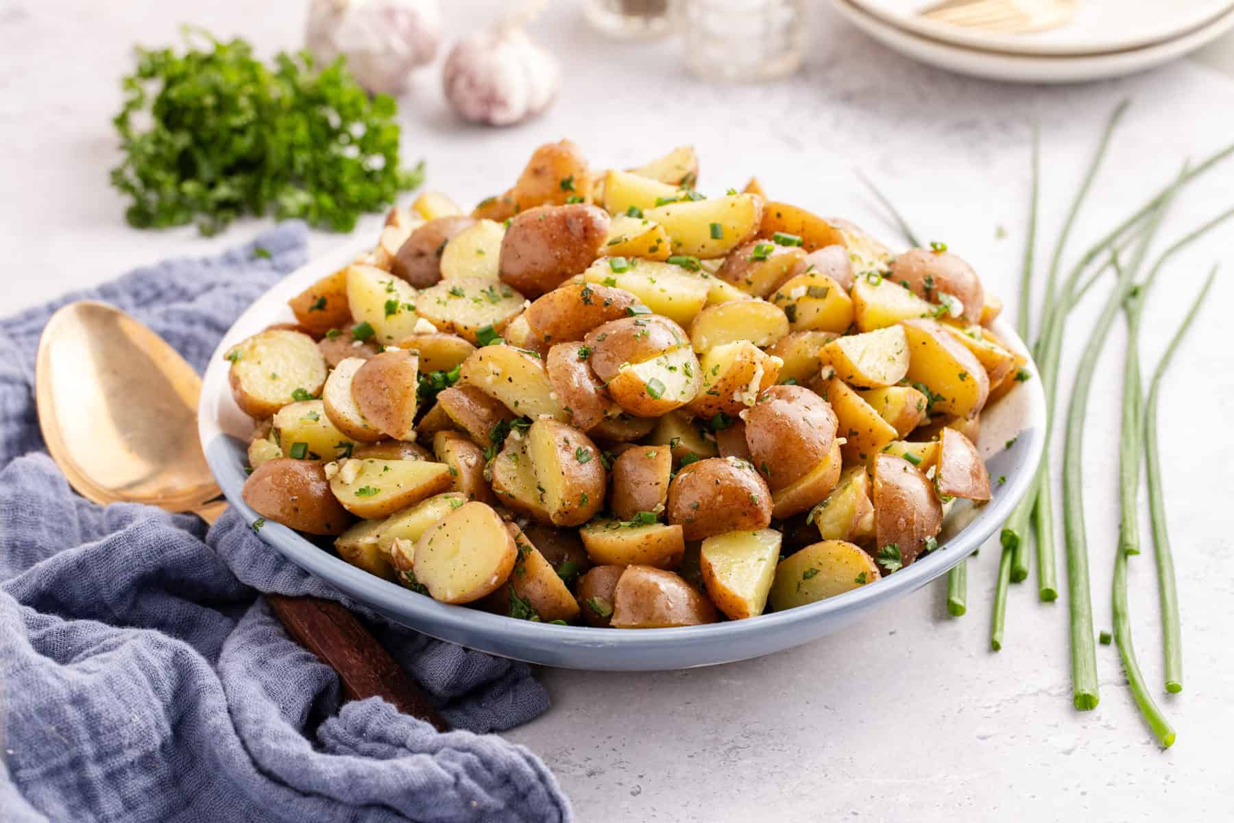 lemon herb red potato salad in a serving bowl garnished