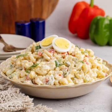 Macaroni Salad in a serving dish with fresh dill and hardboiled eggs on top