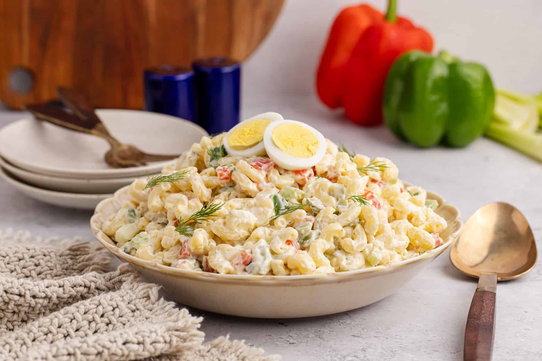 Macaroni Salad in a serving dish with fresh dill and hardboiled eggs on top