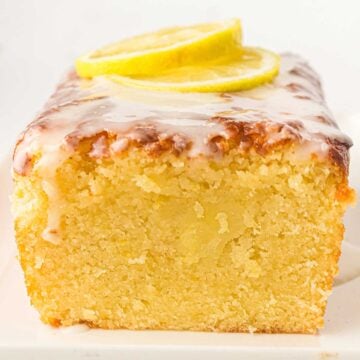 Old Fashioned Lemon Pound Cake sliced to show the moist inside with lemon slices on top