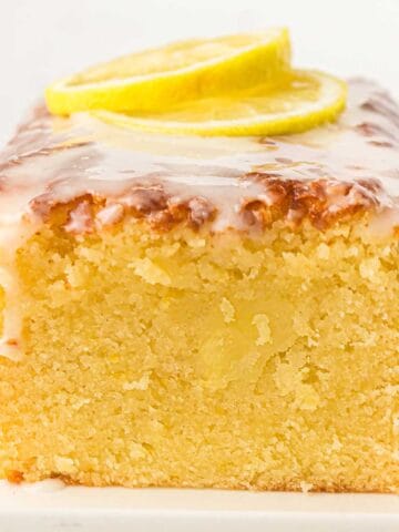 Old Fashioned Lemon Pound Cake sliced to show the moist inside with lemon slices on top