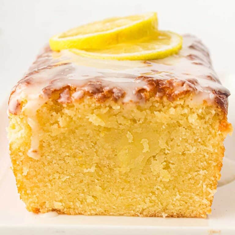 Old Fashioned Lemon Pound Cake sliced to show the moist inside with lemon slices on top