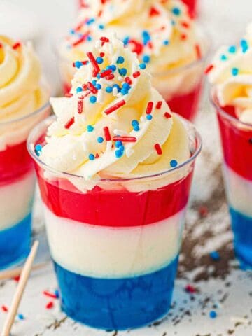 Red, White, and Blue Jello Cups up close with sprinkles and whipped cream