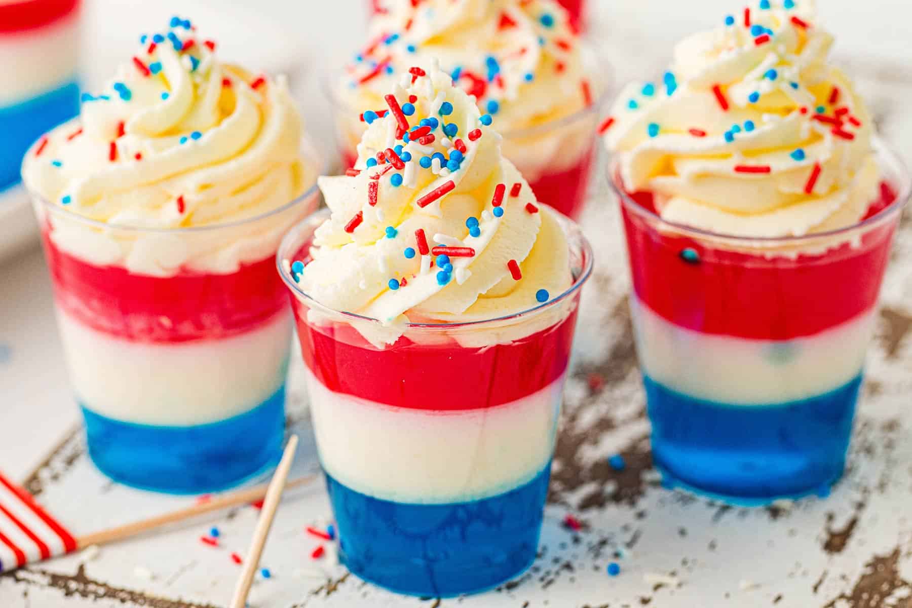 Red, White, and Blue Jello Cups on a counter with sprinkles
