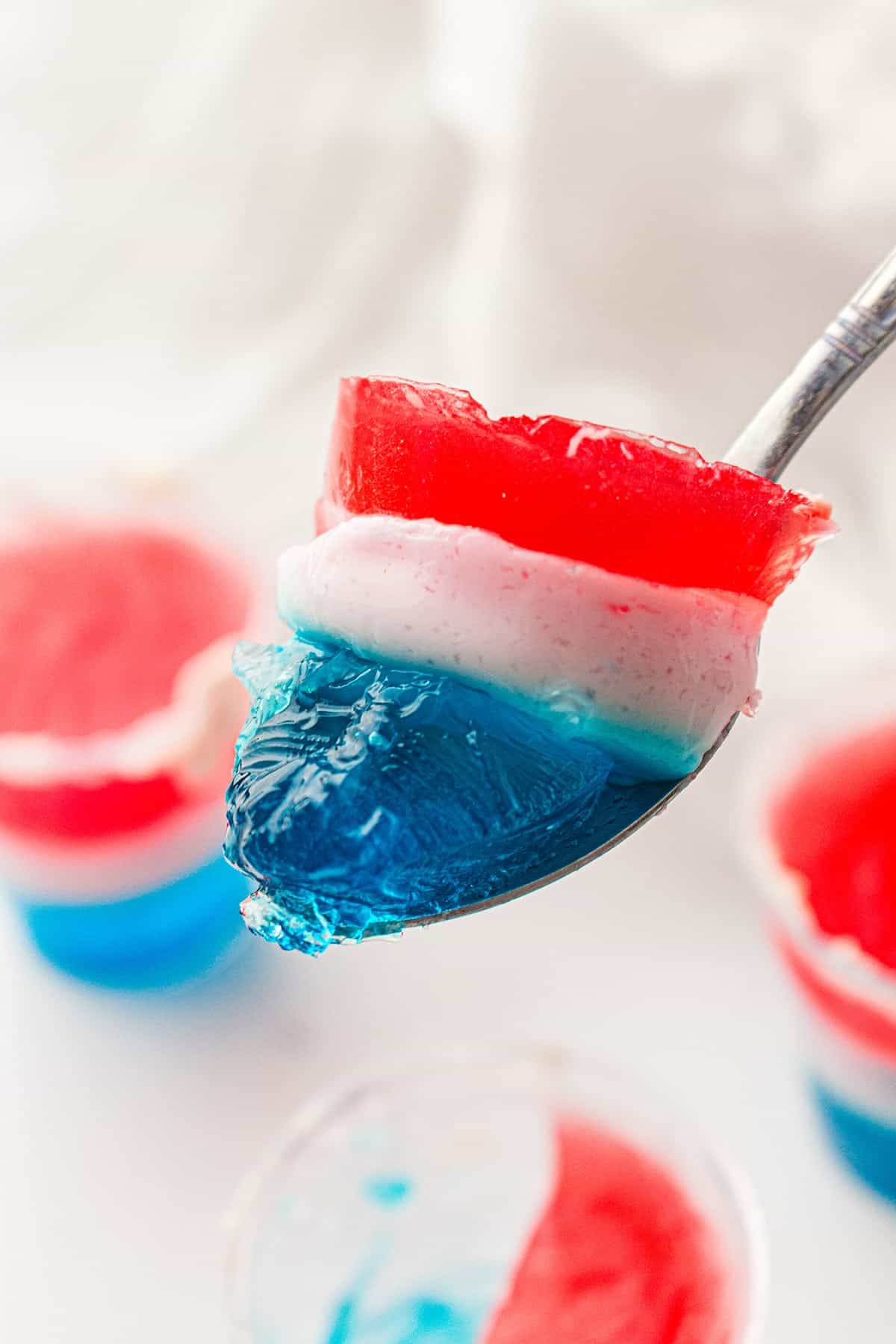 Red, White, and Blue Jello Cups scooped on a spoon