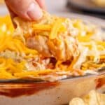Taco Dip with Cream Cheese being scooped up close on a corn chip