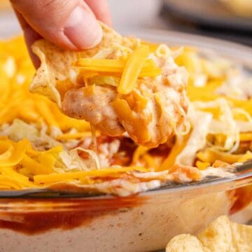 Taco Dip with Cream Cheese being scooped up close on a corn chip