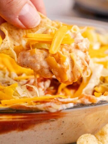 Taco Dip with Cream Cheese being scooped up close on a corn chip