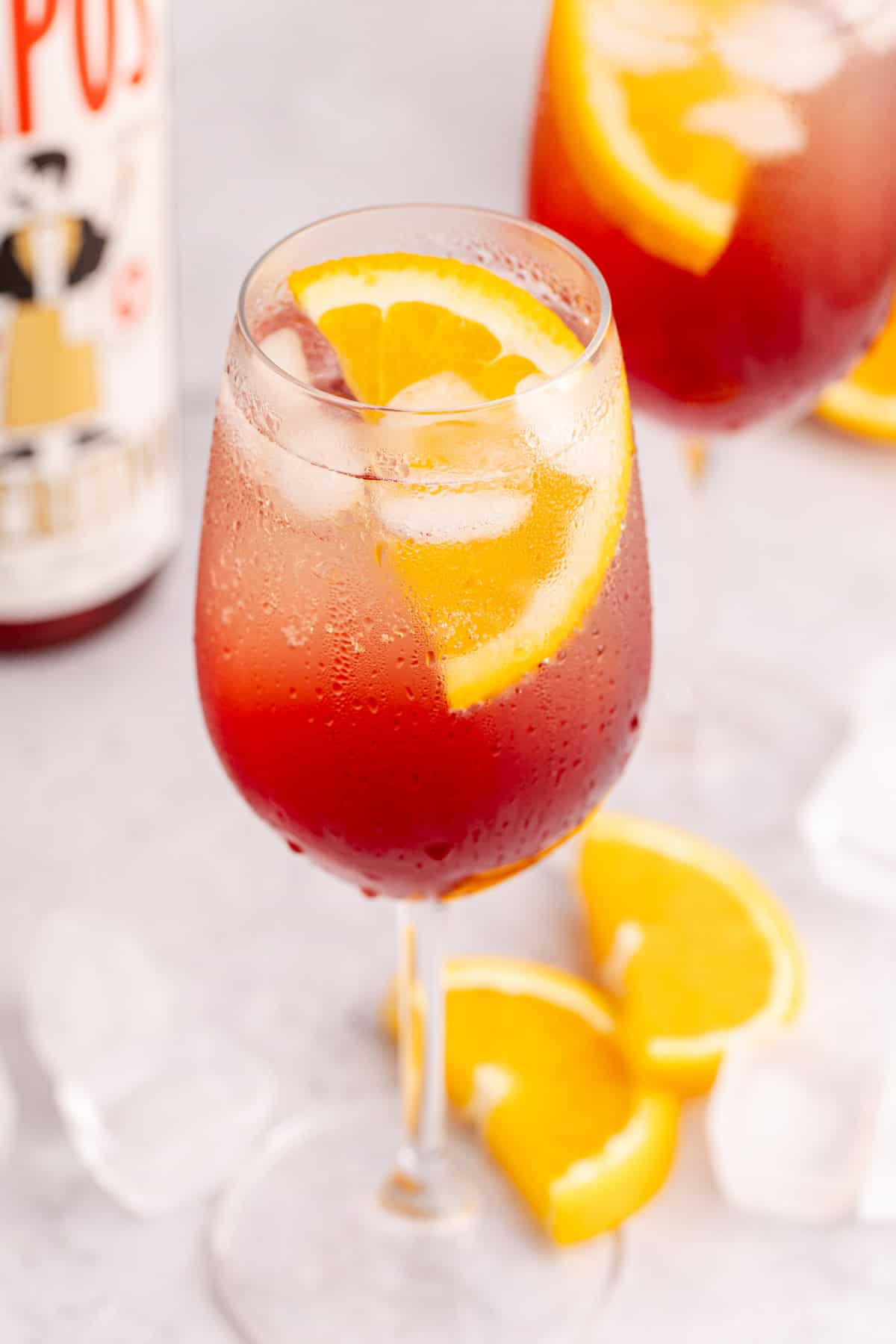 close up of wine glass with aperol spritz mocktail served over ice