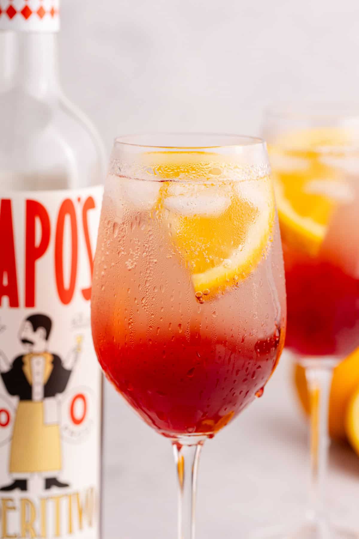 aperol spritz mocktail in wine glass served over ice
