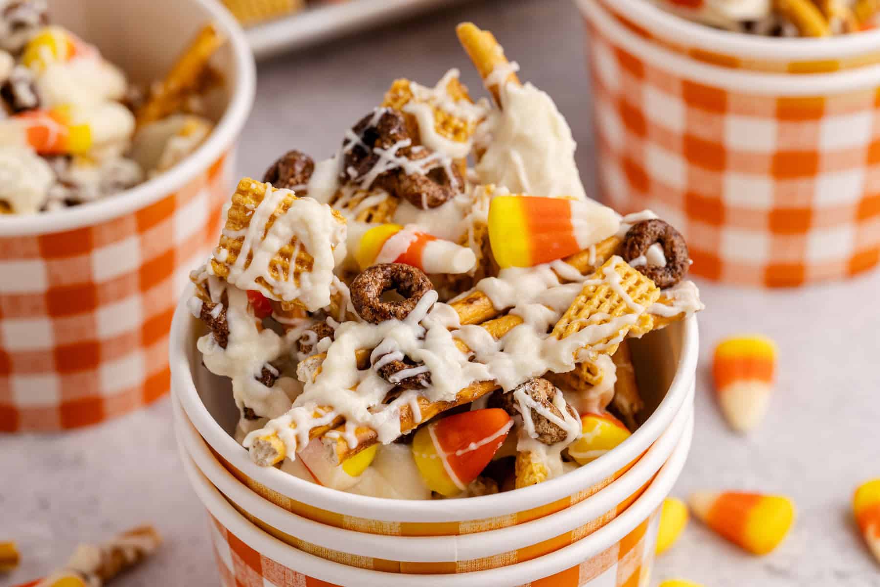 candy corn crunch bark pieces inside a plaid paper cup