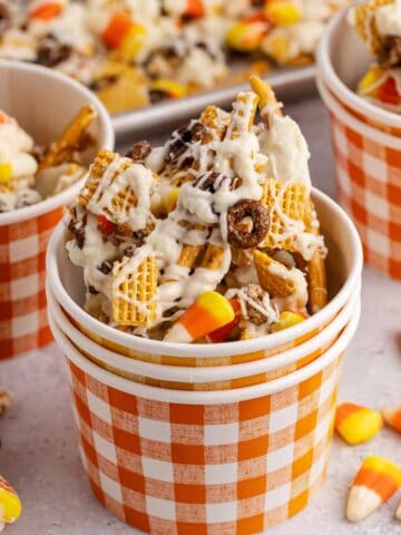 candy corn crunch bark pieces inside a plaid paper cup