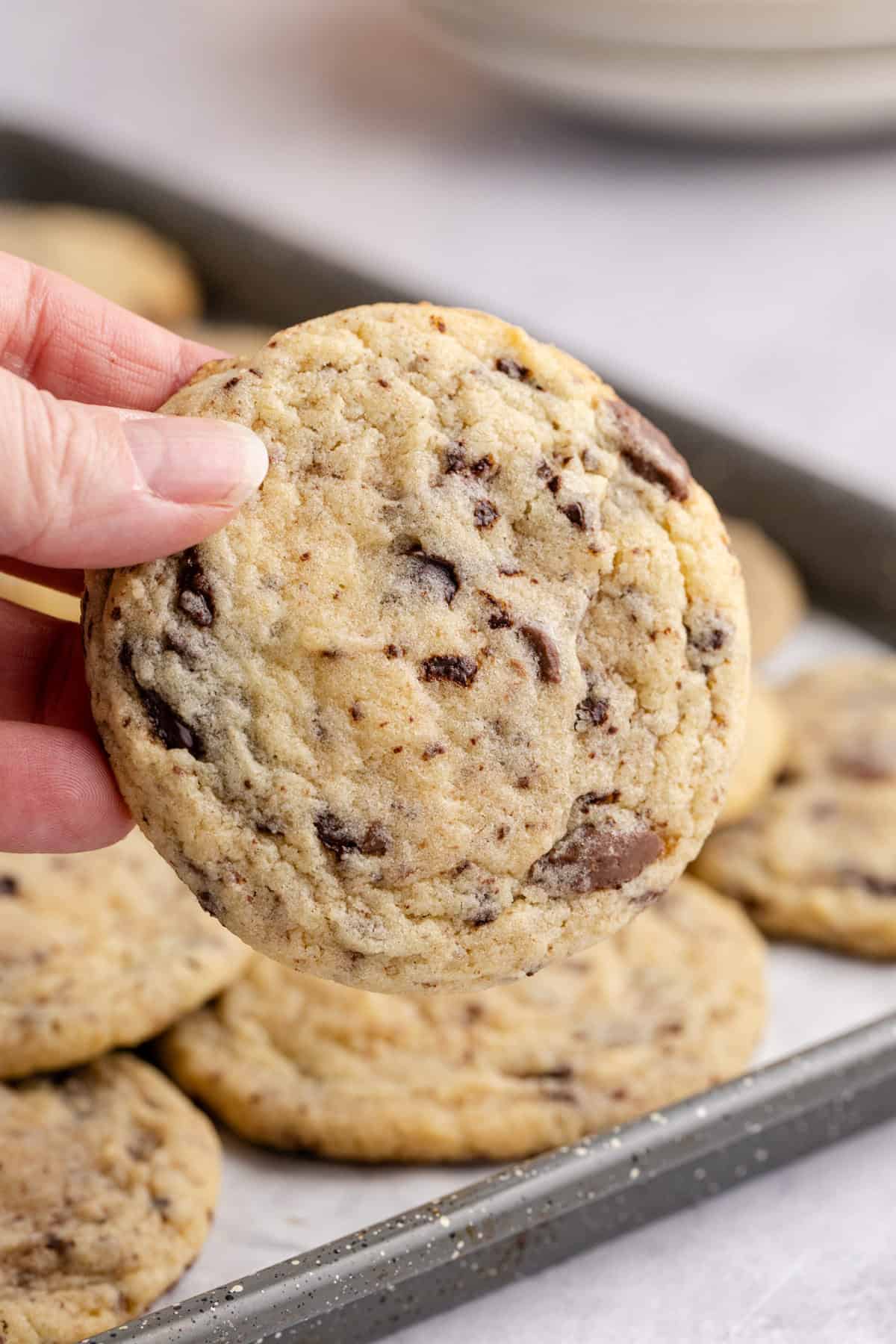 Chocolate Chip Vanilla Pudding Cookies being picked up off a baking sheet