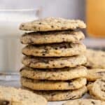 Chocolate Chip Vanilla Pudding Cookies stacked with a glass of milk in the back