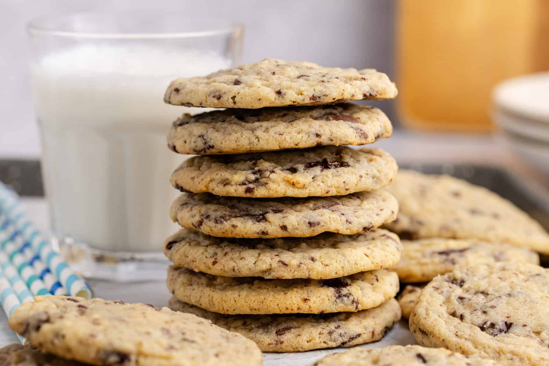 Chocolate Chip Vanilla Pudding Cookies stacked with a glass of milk in the back
