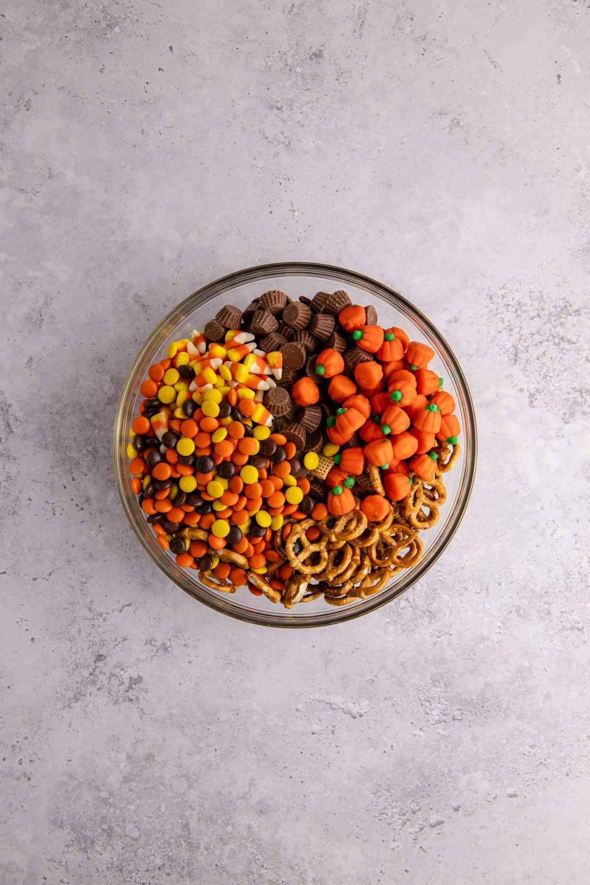 halloween snack mix ingredients in a large mixing bowl