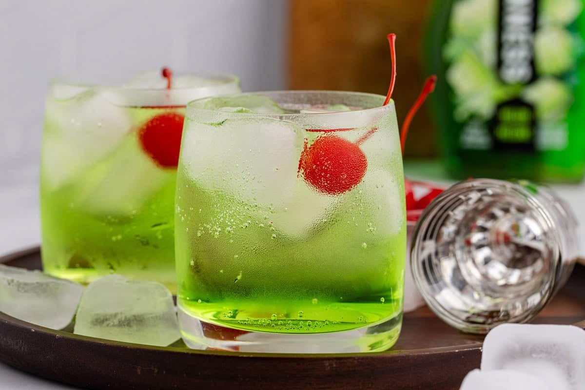 Green Grinch Cocktail Over Ice with Maraschino Cherry