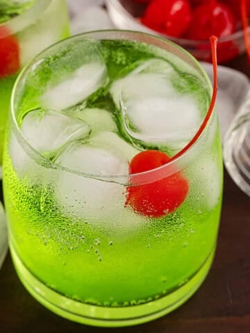 Green Grinch Cocktail Over Ice with Maraschino Cherry
