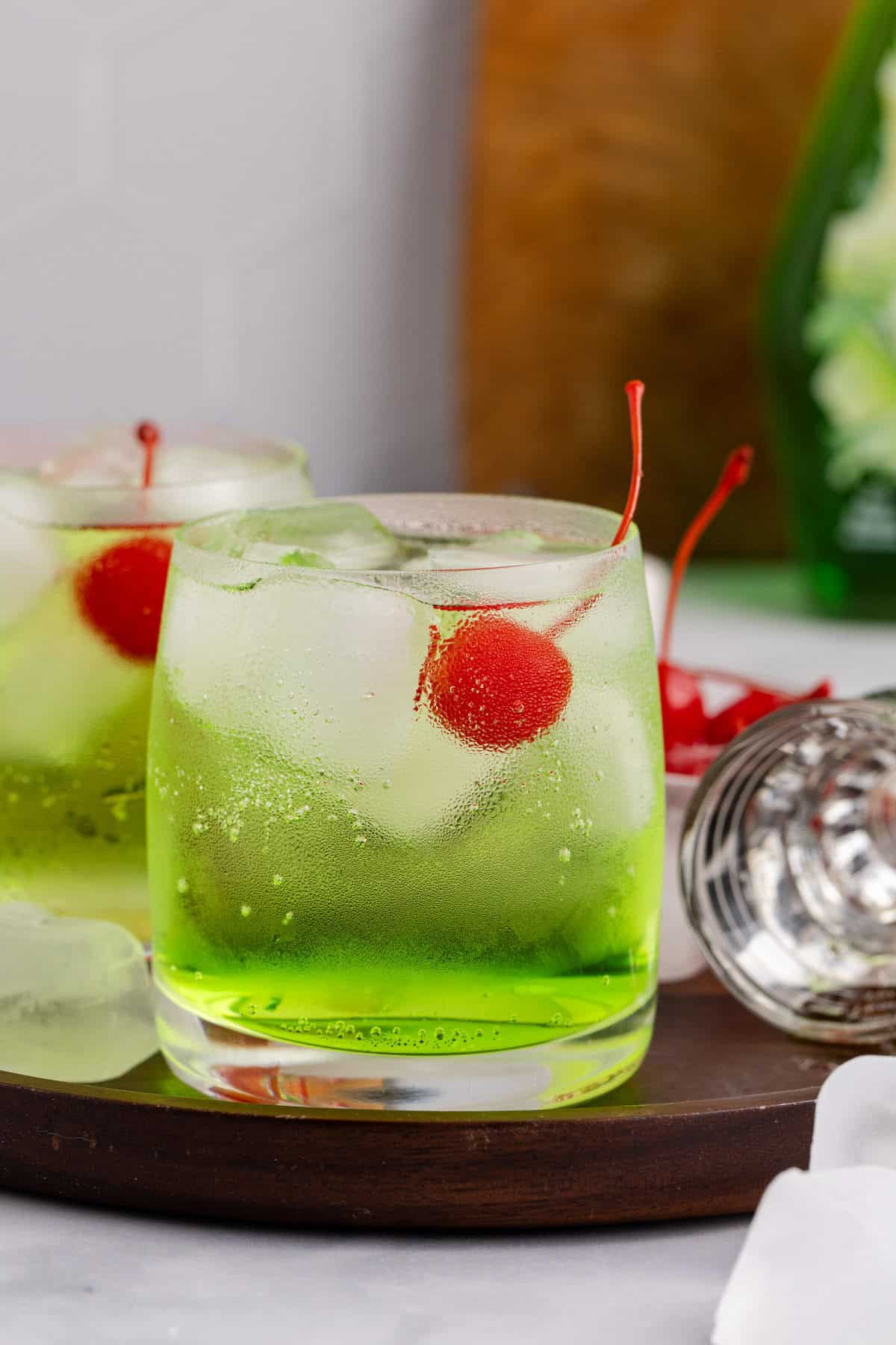 Green Grinch Cocktail Over Ice with Maraschino Cherry