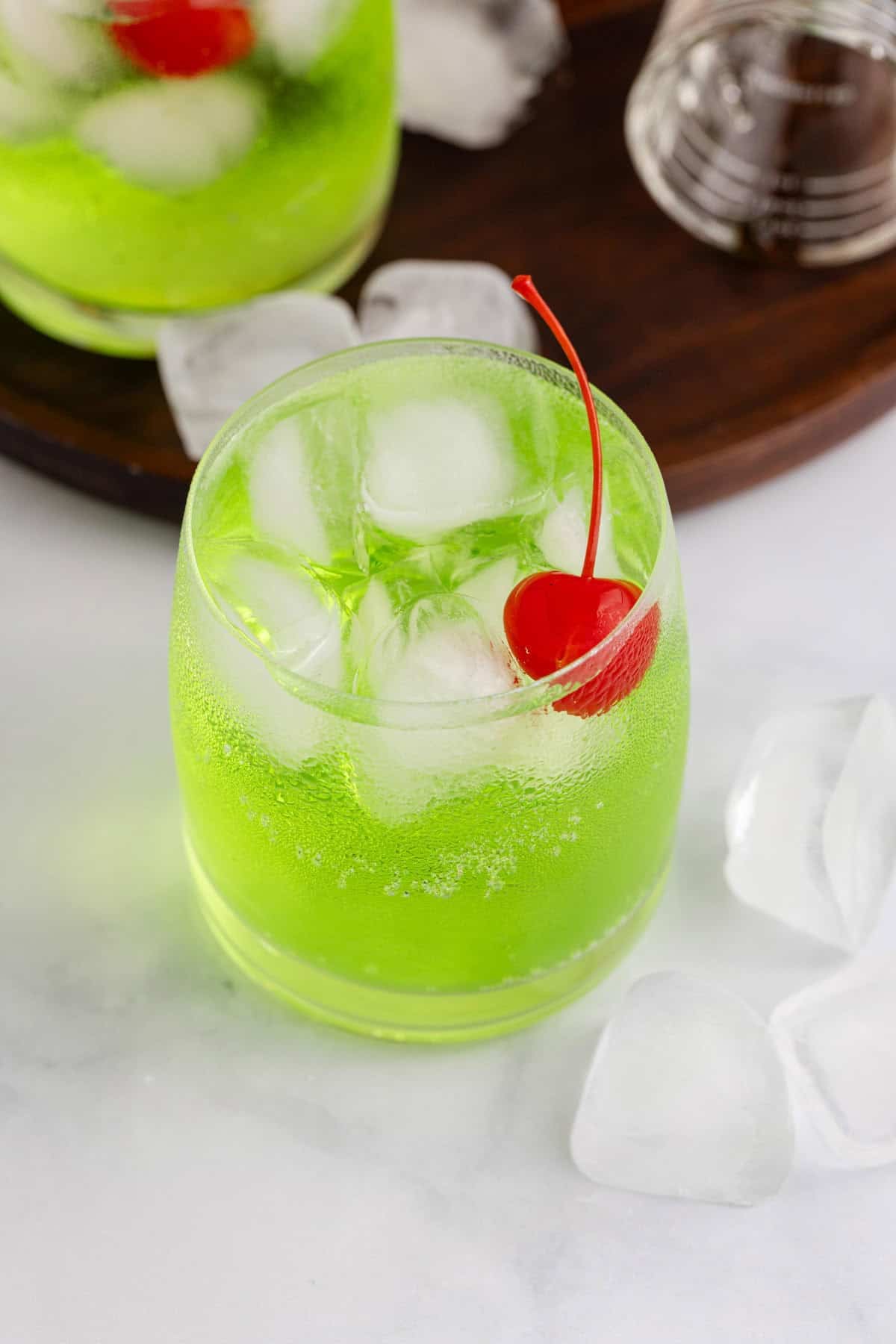 Green Grinch Cocktail Over Ice with Maraschino Cherry