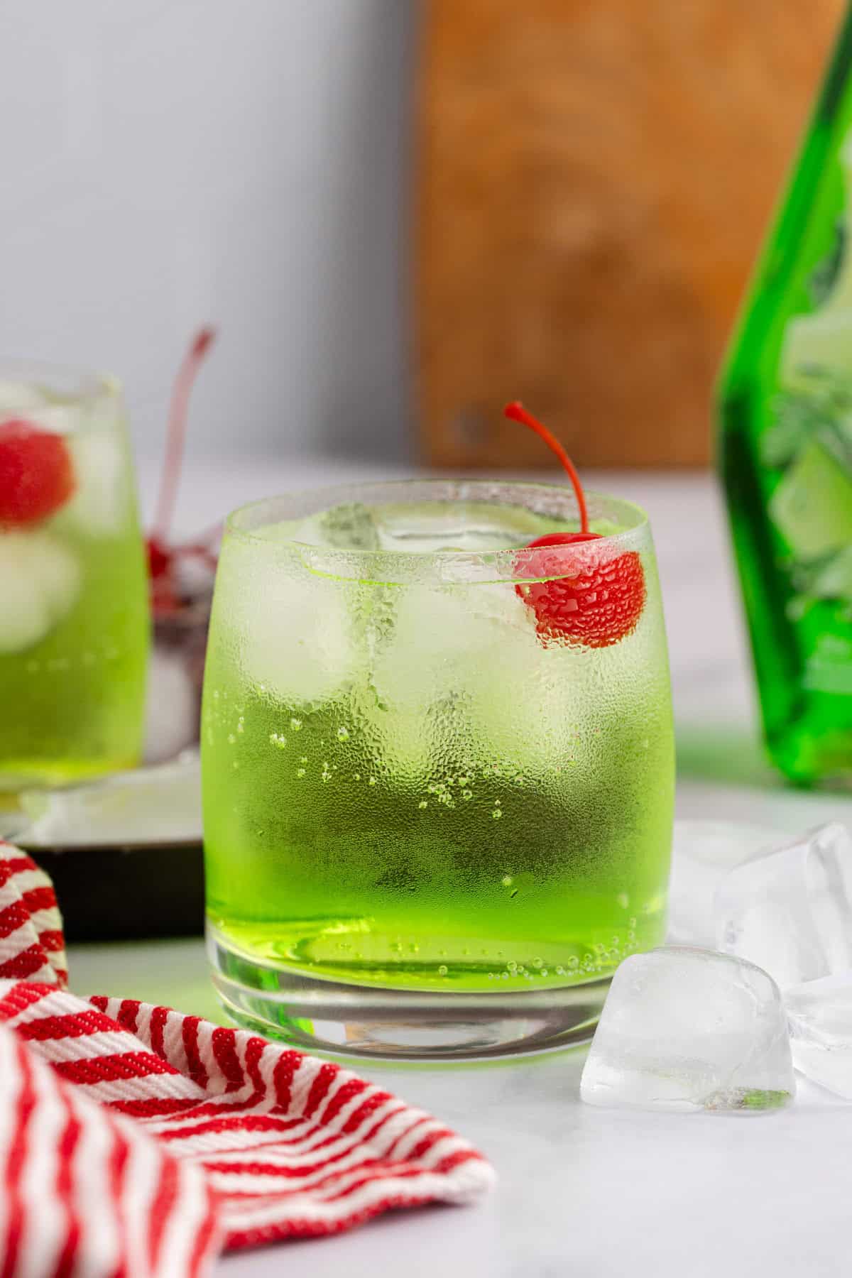 Green Grinch Cocktail Over Ice with Maraschino Cherry