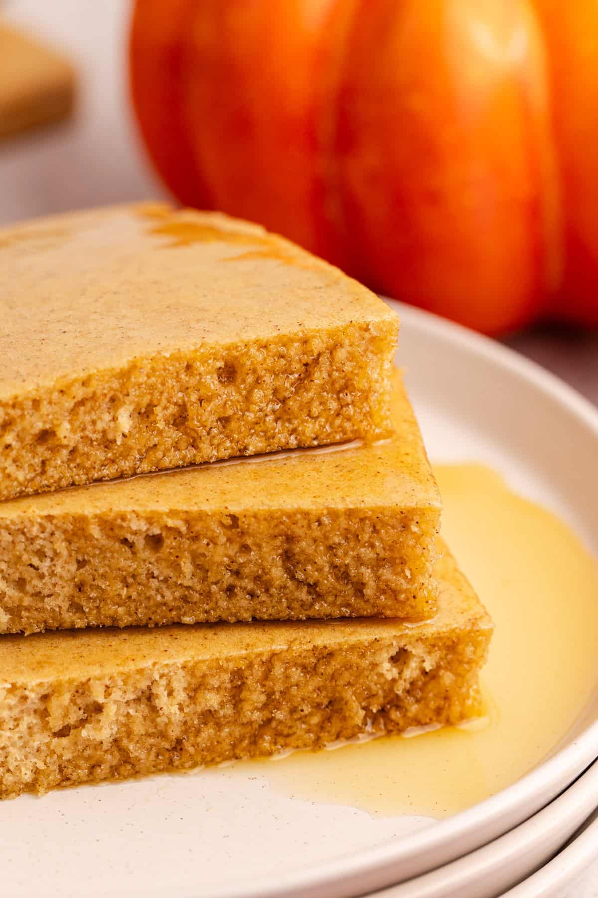 Pumpkin Spice Sheet Pan Pancakes stacked on a plate up close