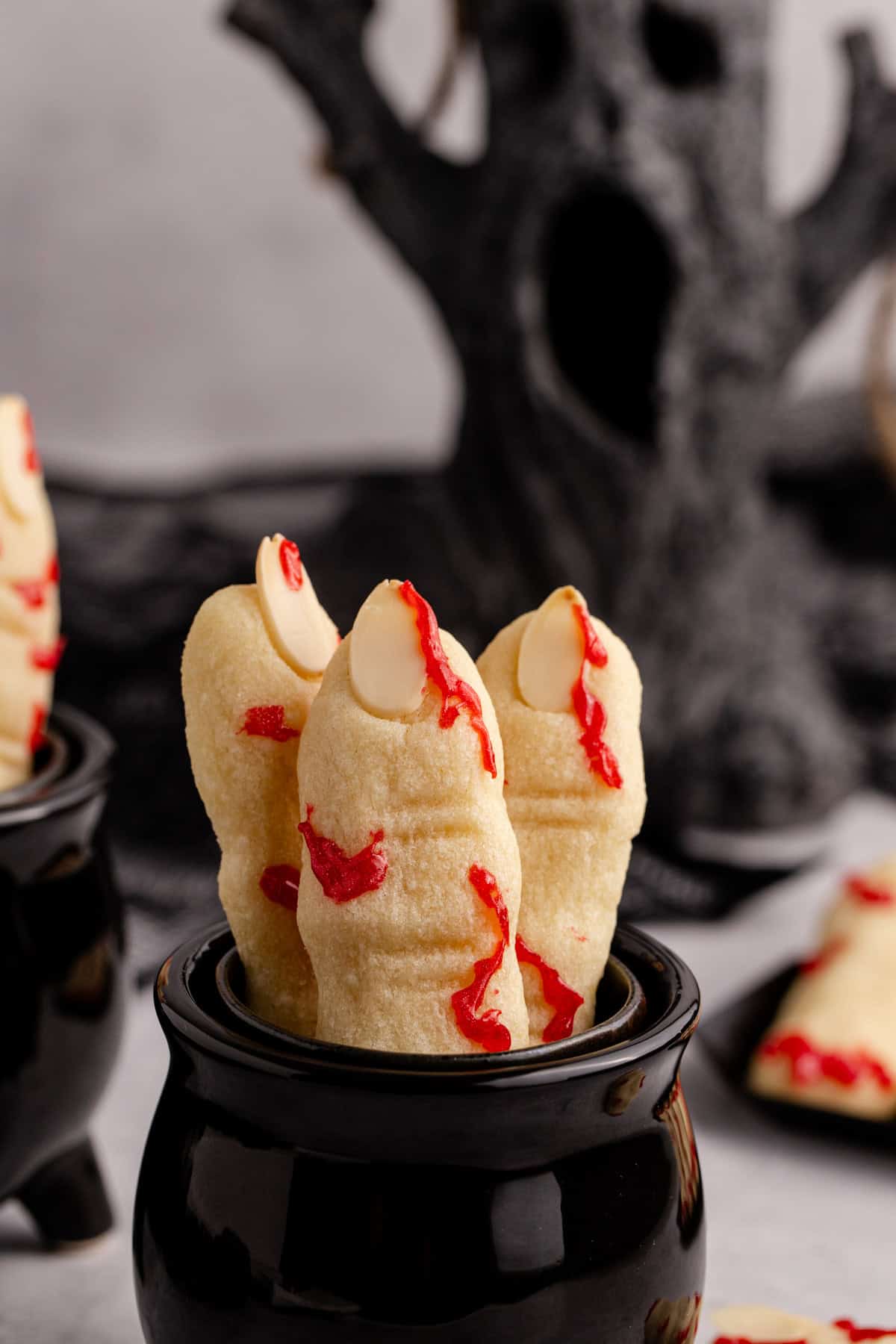Witch Finger Cookies in a cauldron with a creepy tree in the back