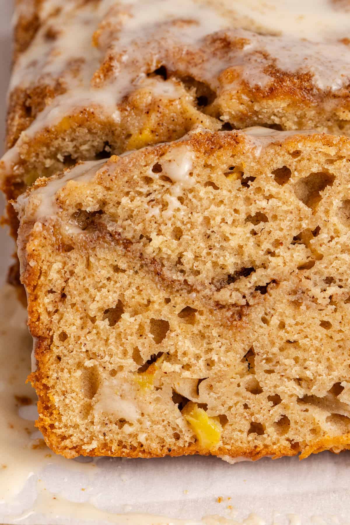 Apple Fritter Quick Bread slice up close to see the fruit and cinnamon swirl