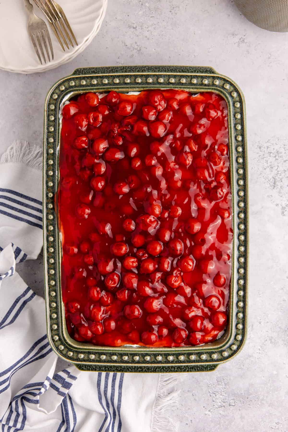 Cherries in the Snow in a casserole dish from above with plates and forks beside