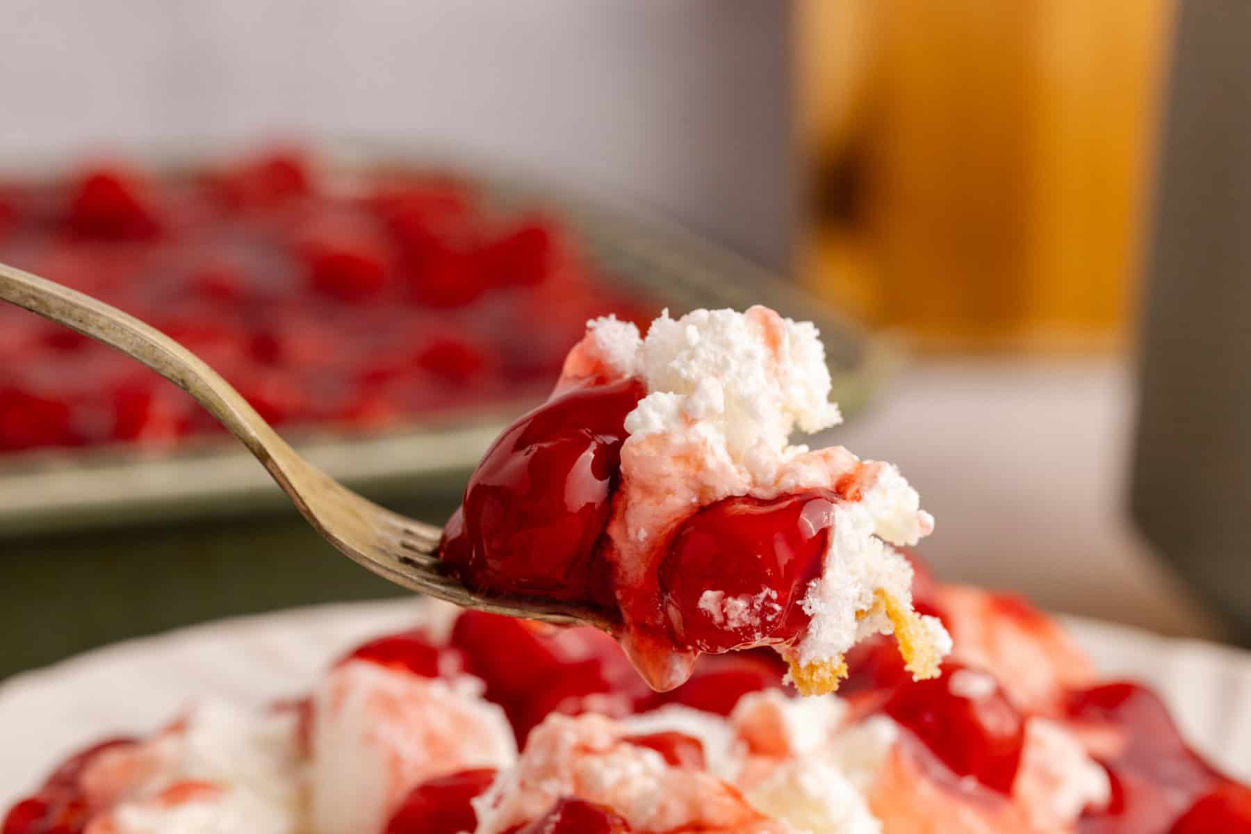 A fork full of Cherries in the Snow hovering over a plate