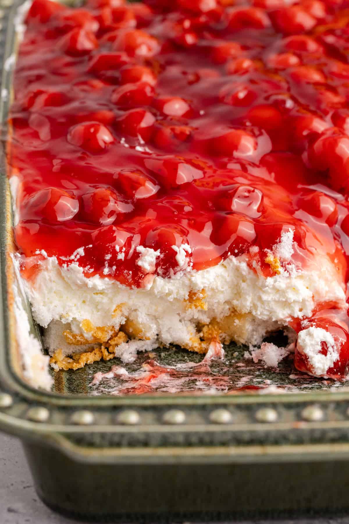 Cherries in the Snow in a baking dish with a scoop taken and the layers are visible