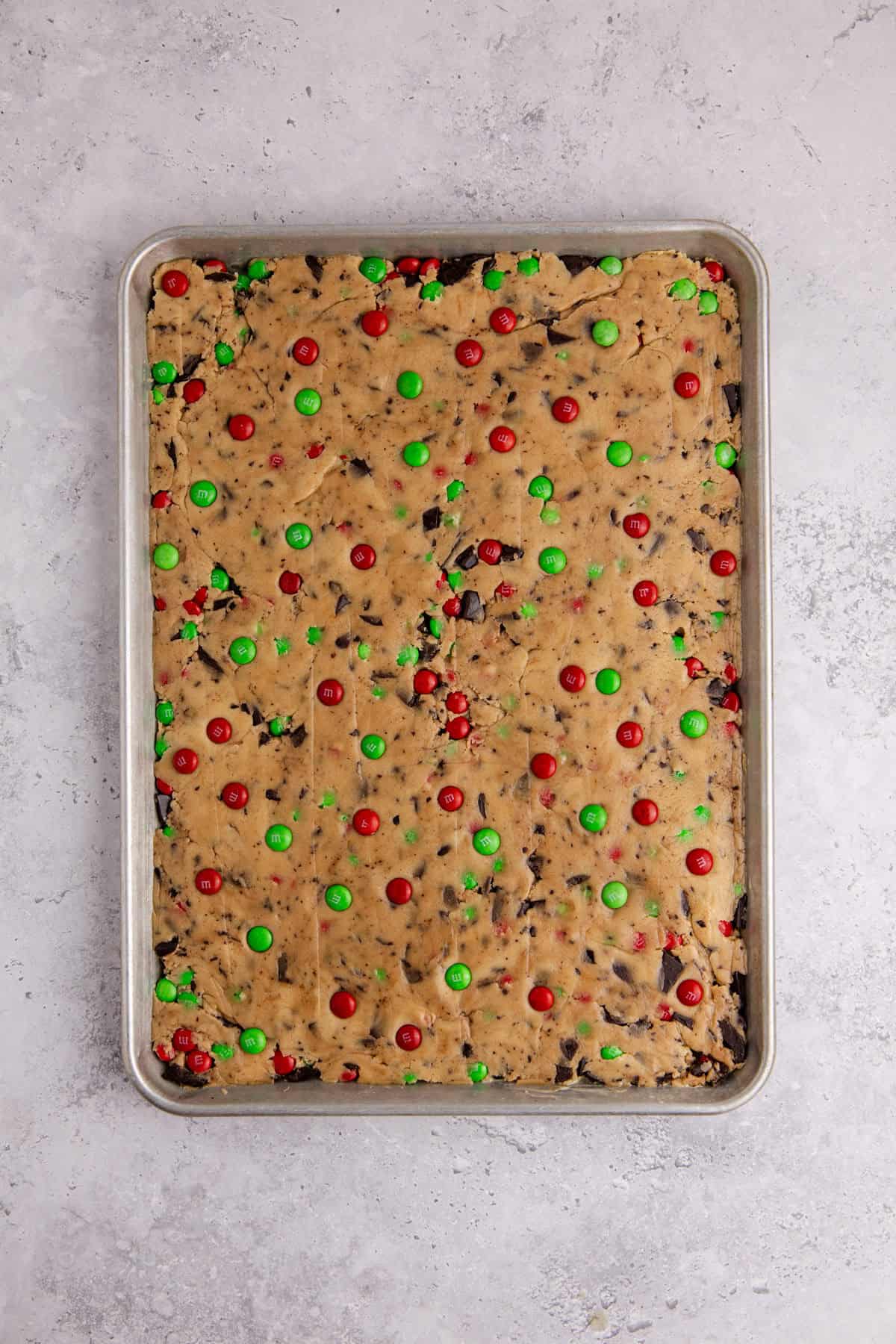 Christmas M&M Cookie Bars from overhead a sheet pan to be baked