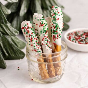 Christmas Pretzel Rods with red, white and green sprinkles in a small jar