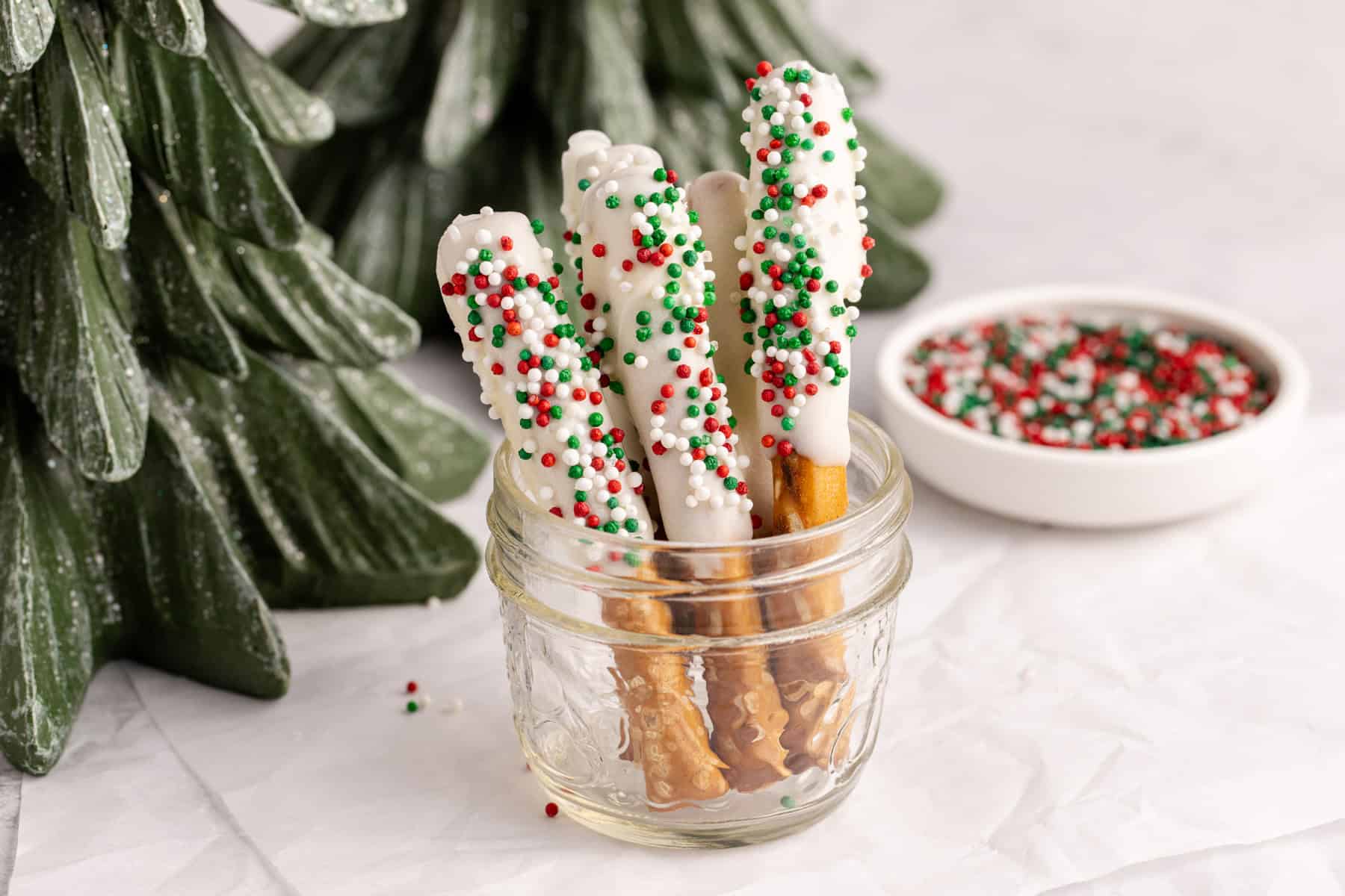 Christmas Pretzel Rods with red, white and green sprinkles in a small jar