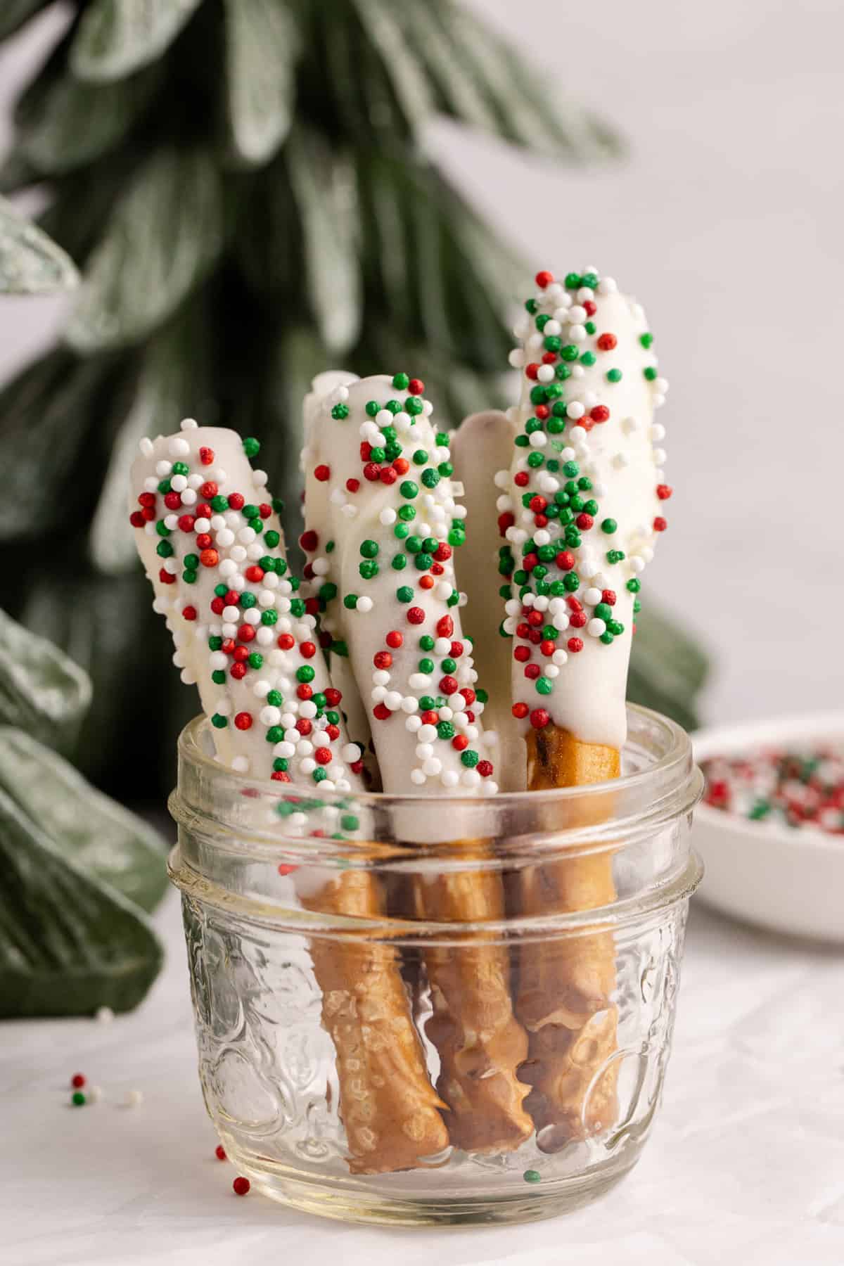 Christmas Pretzel Rods with red, white and green sprinkles in a small jar