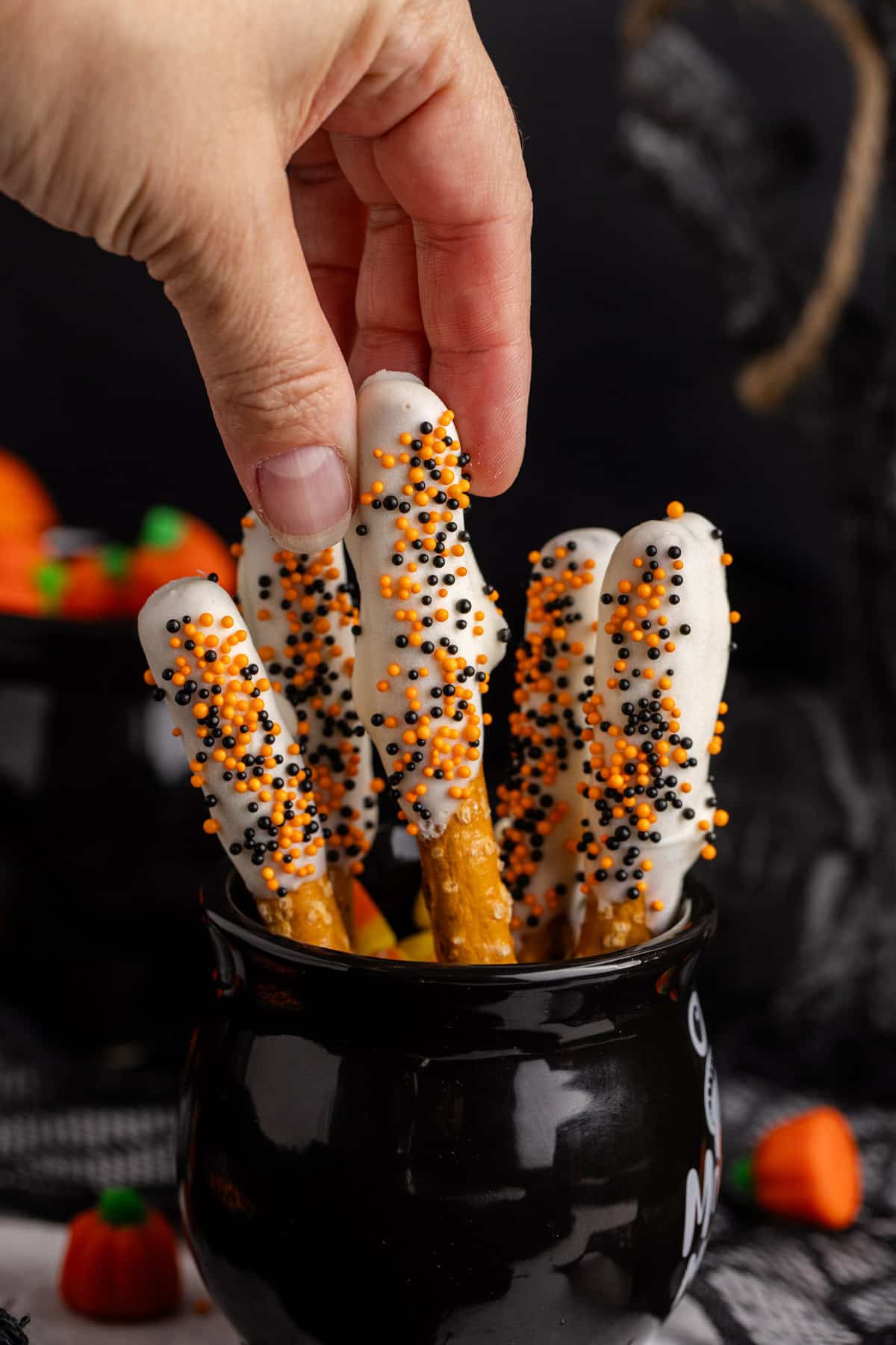 Halloween Pretzel Rods in a cauldron bring lifted up