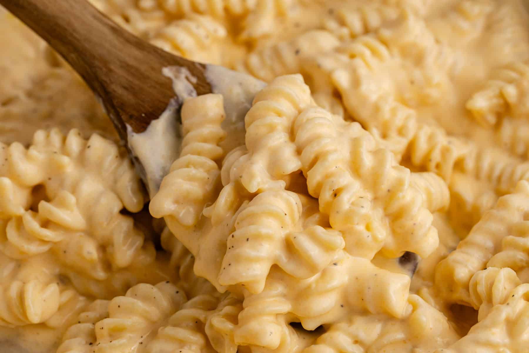 High Protein Mac and Cheese in a skillet up close with a serving spoon