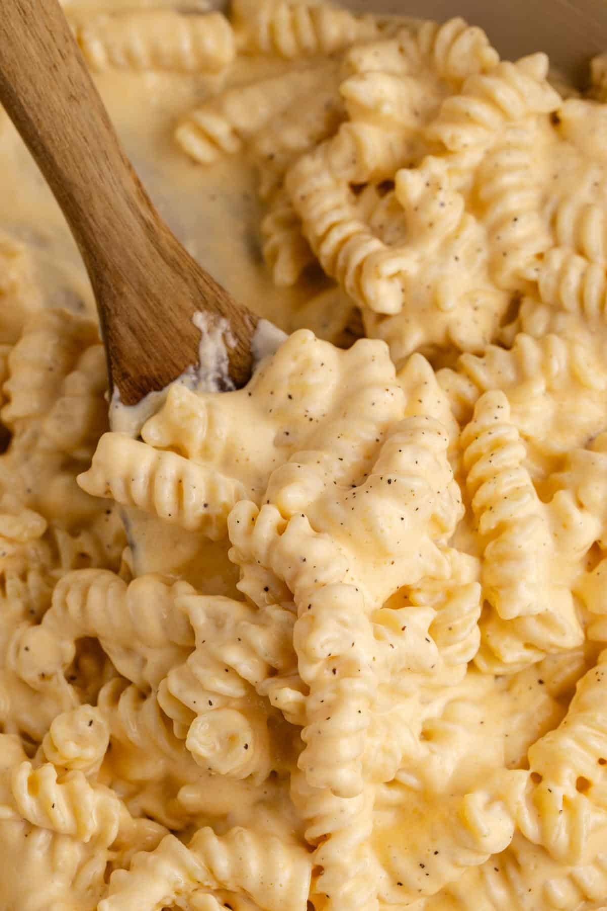 High Protein Mac and Cheese in a skillet up close with a serving spoon